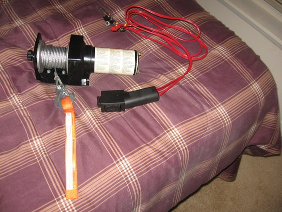 Electric winch with red cables and orange strap