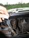 1979 Ford F-150 - Hand holding dome light bulb over exposed dashboard wiring and components.