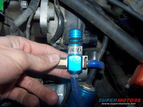 Hand holding blue turbo valve with 'TURBOX' label