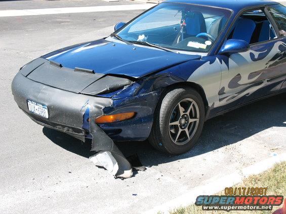 Blue car with flame decals and damaged front end, license plate visible