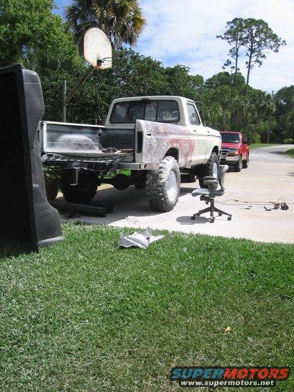 1979 Ford F-150 rear view, white with red accents, undergoing repairs