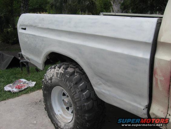 1979 Ford F-150 truck bed and rear fender, primed and ready for paint. Large off-road tire visible