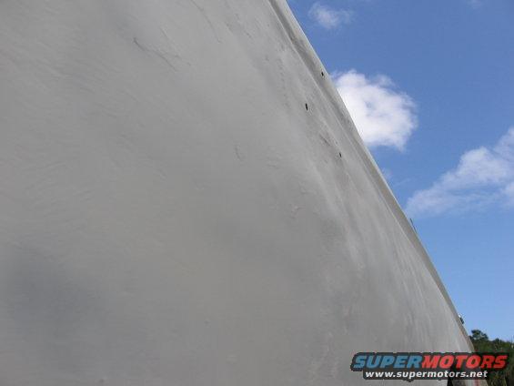 Gray vehicle side panel against blue sky
