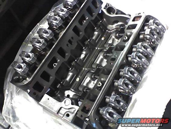 Engine block with visible rocker arms and valve springs, partially covered by plastic