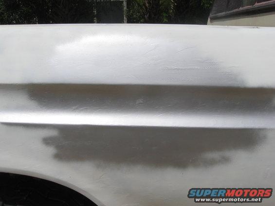 White truck fender with visible body filler and primer