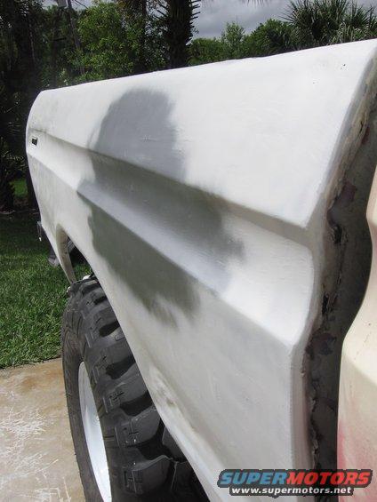 1979 Ford F-150 fender with primer, showing a large off-road tire