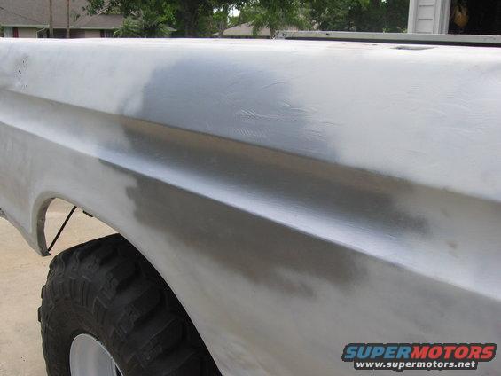 1979 Ford F-150 bed side panel with primer, showing bodywork in progress