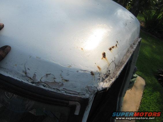 close-up of rusty, peeling paint on a white truck roof edge