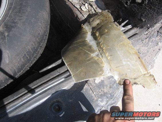 Fiberglass repair on vehicle part next to tire
