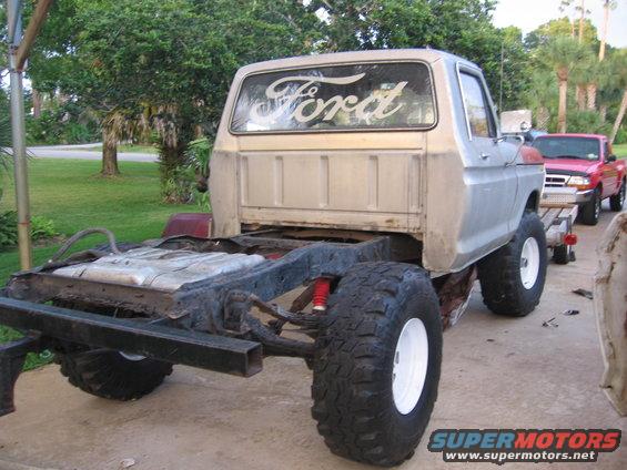 1979 Ford F-150 chassis with cab, rear view. Another red Ford pickup is visible behind it