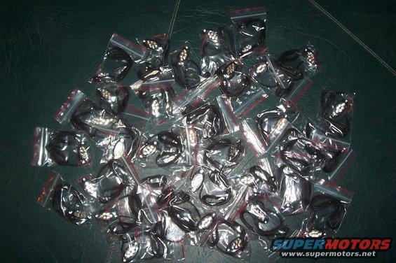 Pile of black car emblems in plastic bags