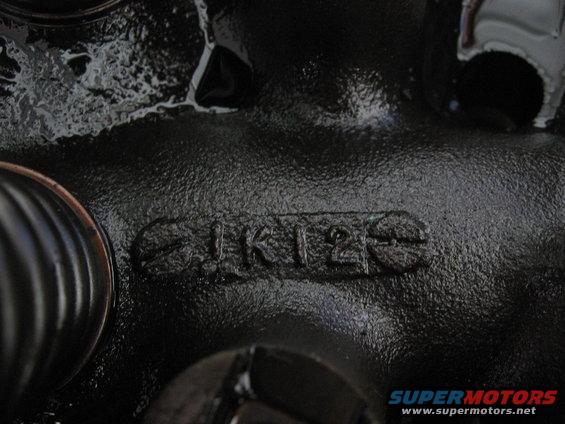 Engine part casting with numbers 1K125 visible. Supermotors.net logo in corner