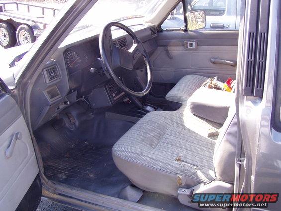 1989 Ford F-250 interior showing worn striped cloth seats, dashboard with gauges, and steering wheel