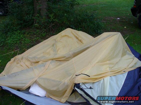 Partially set up camping tent with yellow and blue fabric, outdoors