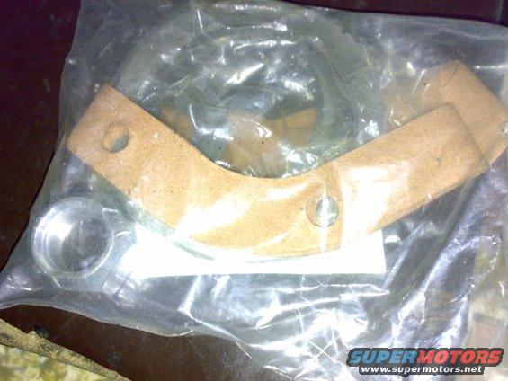 Brake shoe kit in plastic packaging, showing a metal ring and a curved friction material piece