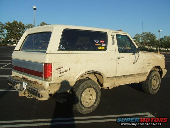 1990 Ford Bronco, rear 3/4 view, covered in dirt, with 'IN PROGRESS' sticker and JEGS sticker on the side