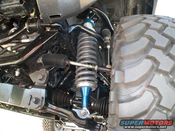 Close-up of a vehicle's front suspension with a large off-road tire