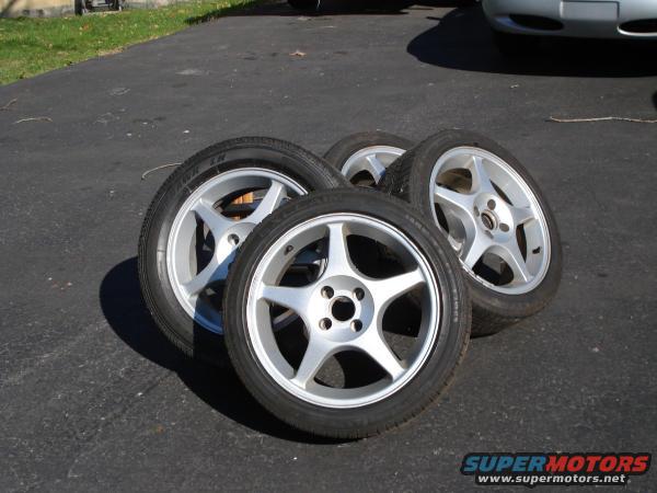 four alloy wheels with tires on pavement