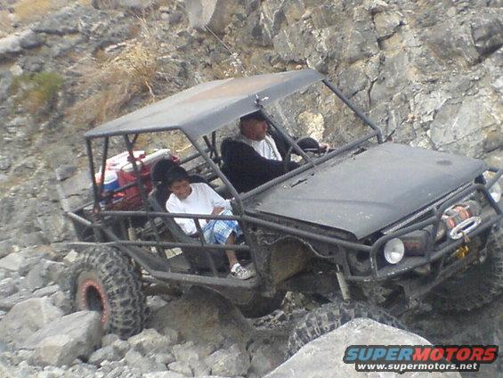 Black off-road buggy with roll cage climbing rocks