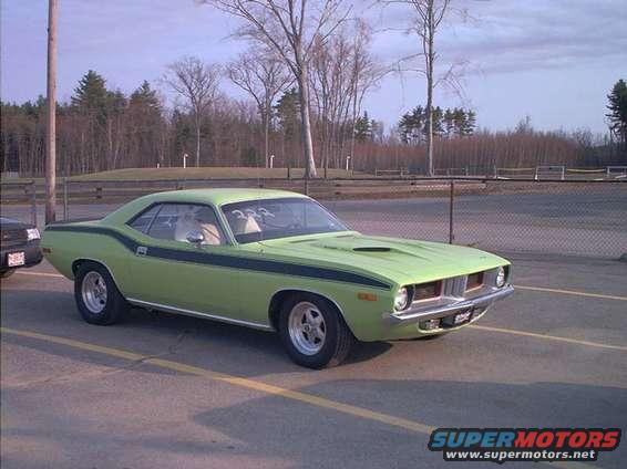 Lime green muscle car with black racing stripes parked on asphalt