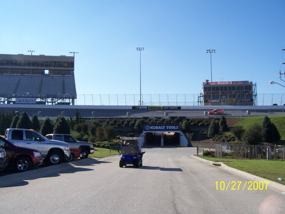 Atlanta Motor Speedway with grandstands, track, and a tunnel entrance. A golf cart is driving on the road