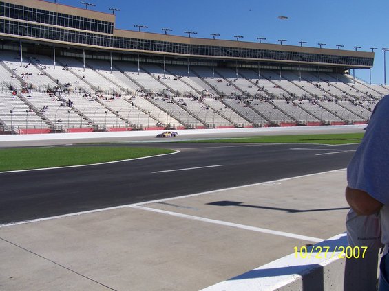 Race car on a track with grandstands in the background