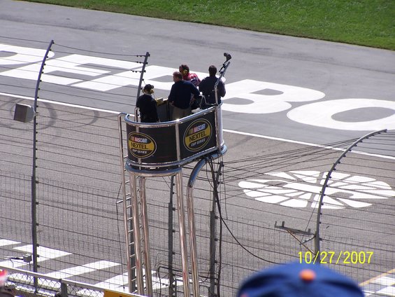 Commentator's booth with NASCAR Nextel Cup Series logos overlooks a race track with white markings
