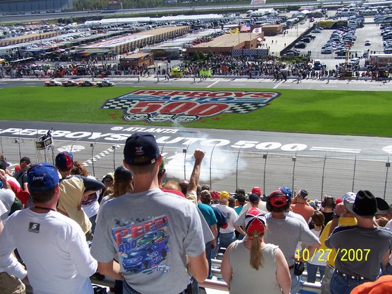 Pep Boys 500 race logo on grass, race cars on track, spectators in stands, date 10/27/2007