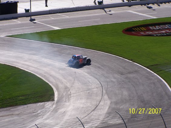 Stock car with number 17 on its side, drifting on a race track with smoke coming from its tires