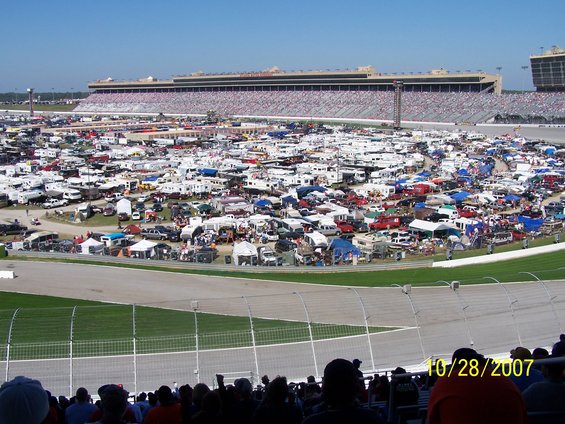 Packed parking lot with RVs and cars at a race track, grandstands in background. Date stamp 10/28/2007
