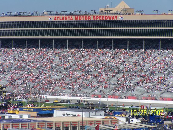 Grandstands filled with spectators at Atlanta Motor Speedway, with a race track visible below
