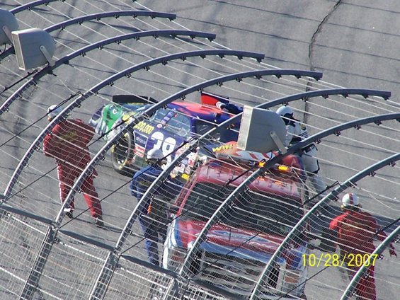 Race cars and safety crew on track with date 10/28/2007 visible