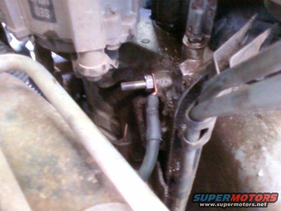 Close-up of a metal component with a hose attached, likely part of an engine