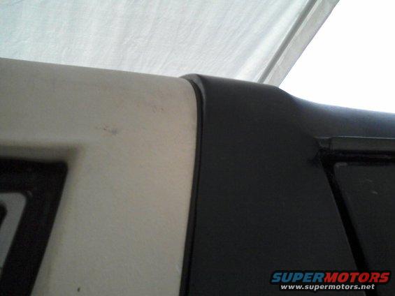 Close-up of a black trim piece against a light-colored vehicle body panel