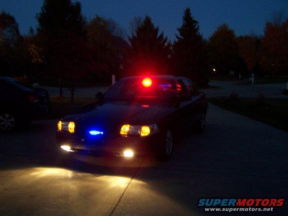 car with red and blue lights on, parked at night