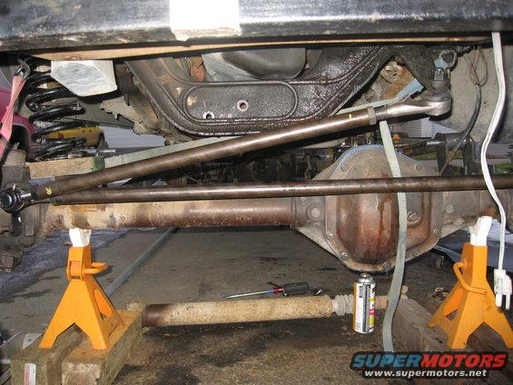 Undercarriage of a 1990 Ford F-250, showing the front axle, suspension, and steering components