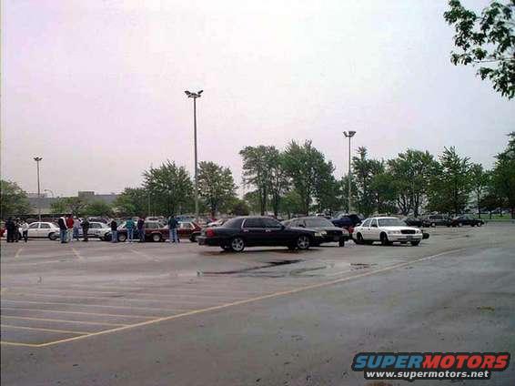 Cars parked in a lot with people milling around