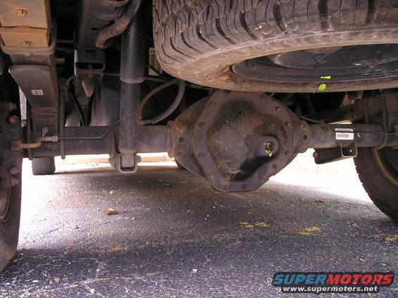 Underside view of a vehicle's rear axle, leaf springs, and shock absorber
