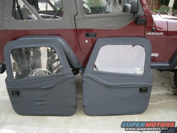 Two black soft doors with windows removed, leaning against a red Jeep Wrangler. "WRANGLER" and "Jeep" badges are visible