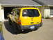 2003 Nissan Xterra - Yellow 2003 Nissan Xterra parked in a driveway with the garage door open.