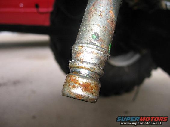 Close-up of a rusted metal pipe fitting with a green mark