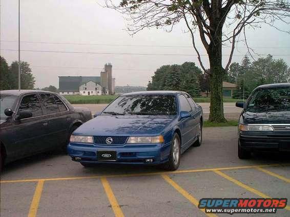 Blue coupe parked in a lot, front view