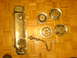 1985 Ford Bronco - Chrome valve cover and four hubcaps are laid out on a wooden floor.