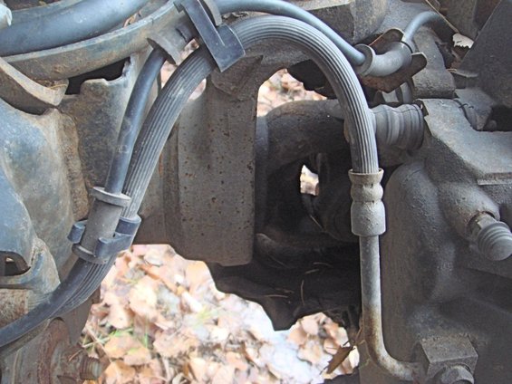 Close-up of rusty brake lines and suspension parts on a vehicle