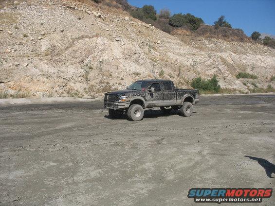 Black Ford F-250 Super Duty truck with lifted suspension parked on dirt road