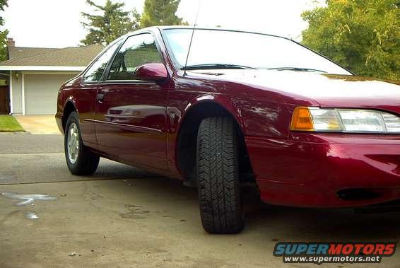 Red 1995 Ford Thunderbird coupe parked on a driveway, front 3/4 view