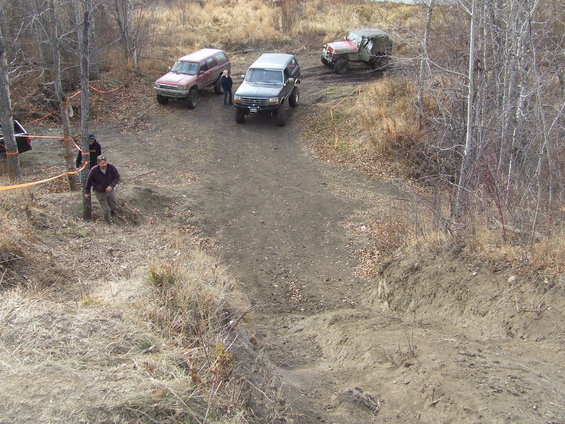 1990 Ford Bronco and other off-road vehicles on a dirt trail