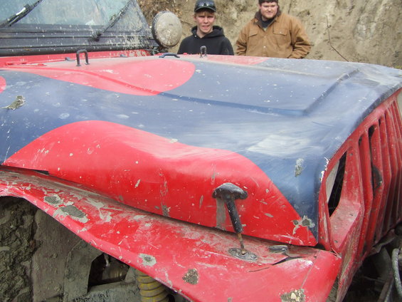 Red and blue camouflage Jeep Wrangler hood with dents and scratches, front view