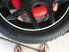 1996 Ford Probe - Close-up of a car wheel and tire assembly, showing the tire's tread and a red brake caliper.