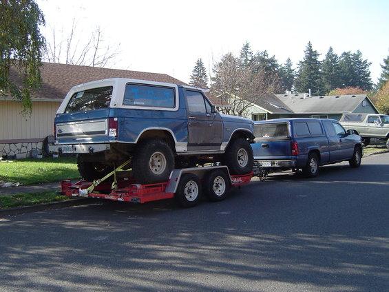 Blue and white SUV on trailer, 1980s body style